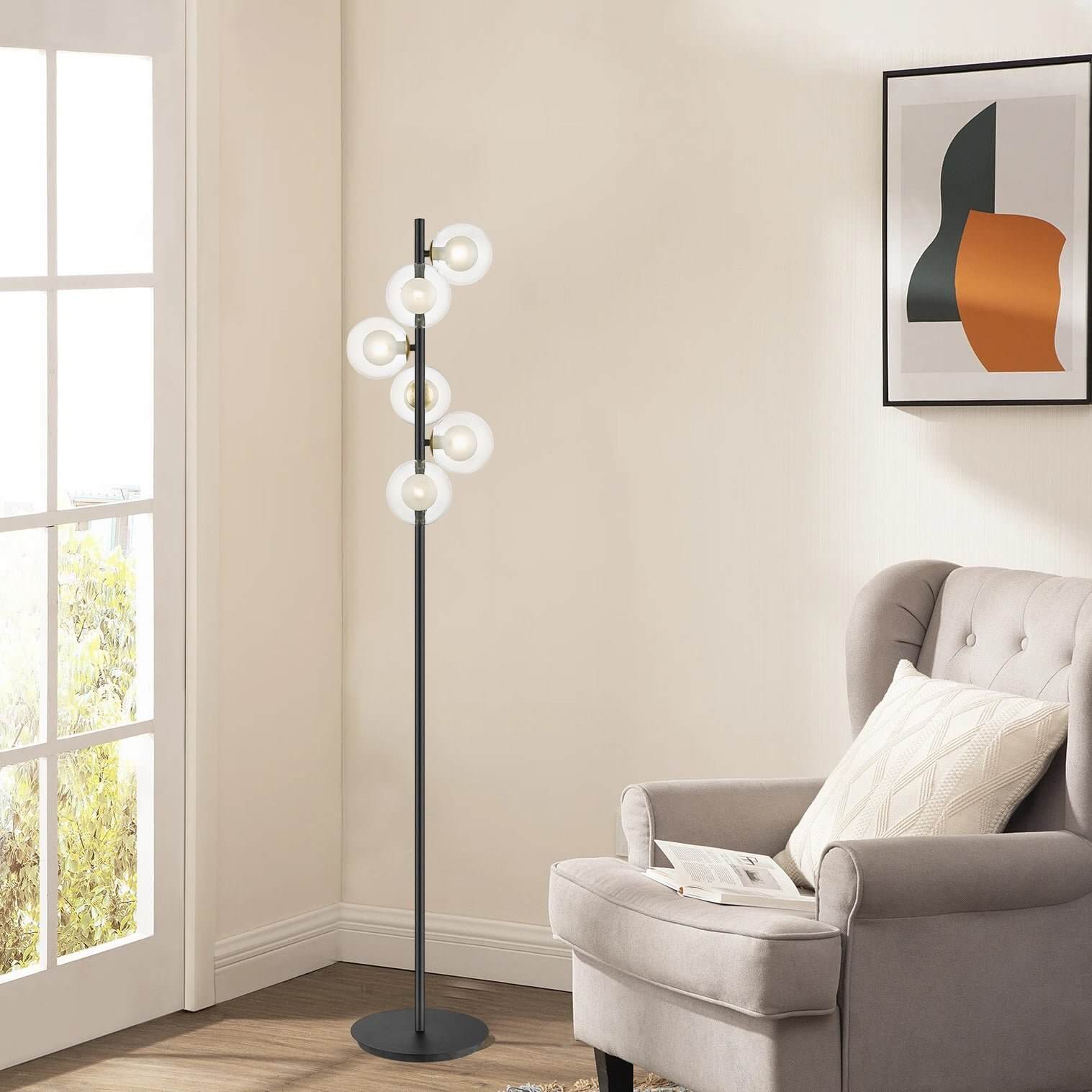 Black floor lamp with six glowing ring lights arranged vertically in a cozy corner.