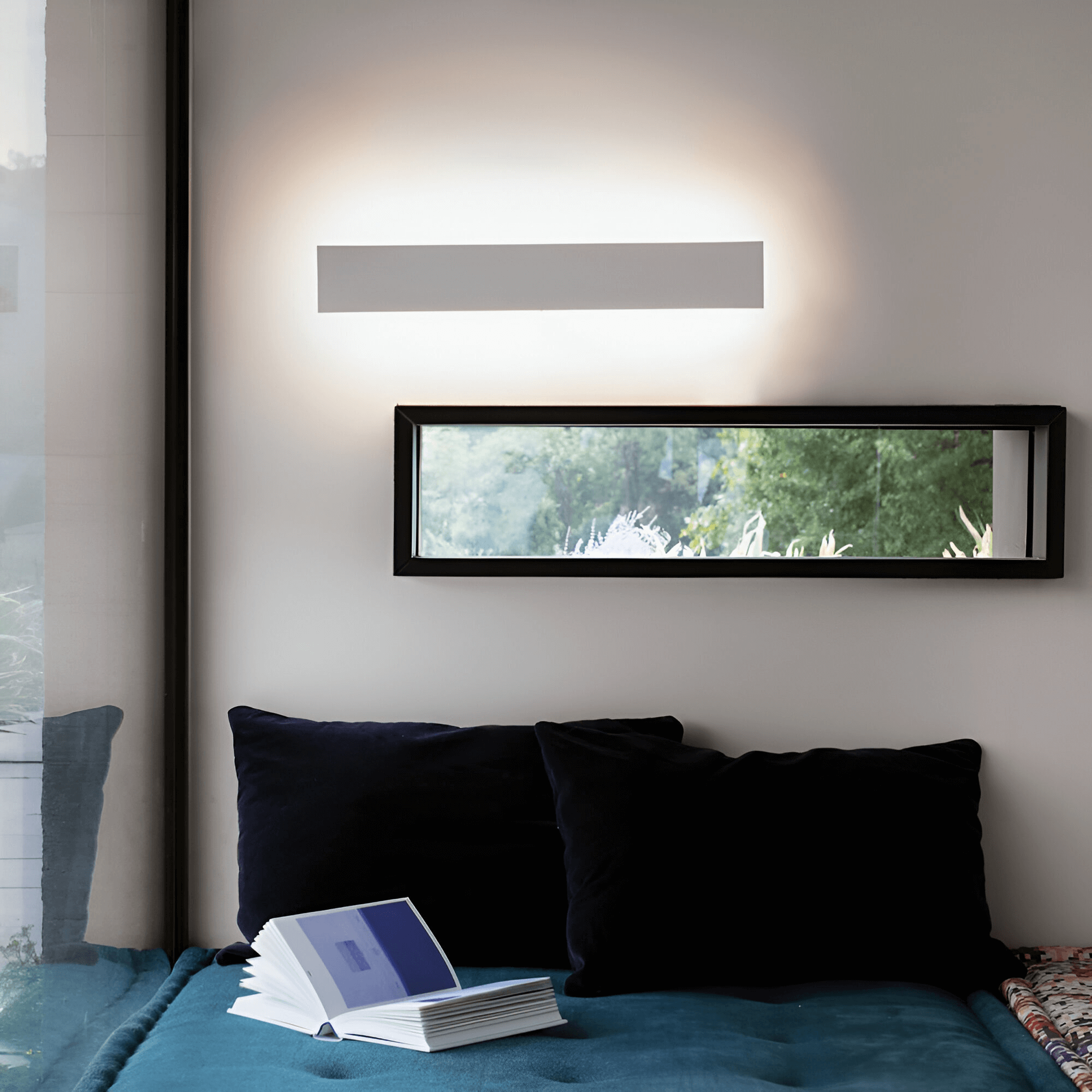 Minimalist rectangular wall light casting upward and downward ambient lighting in a modern living space.