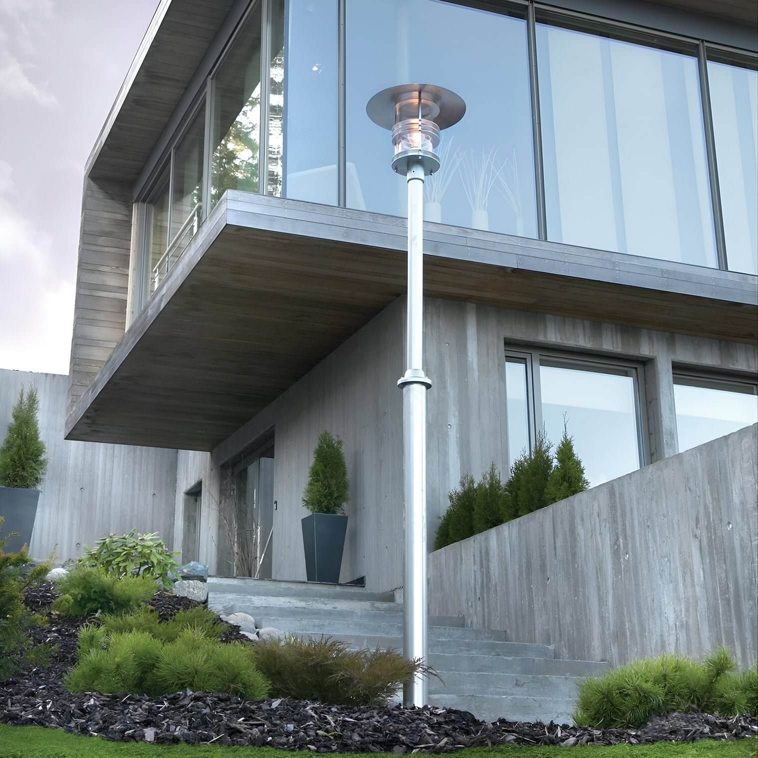 Contemporary silver lamp post in front of a modern concrete house with glass windows