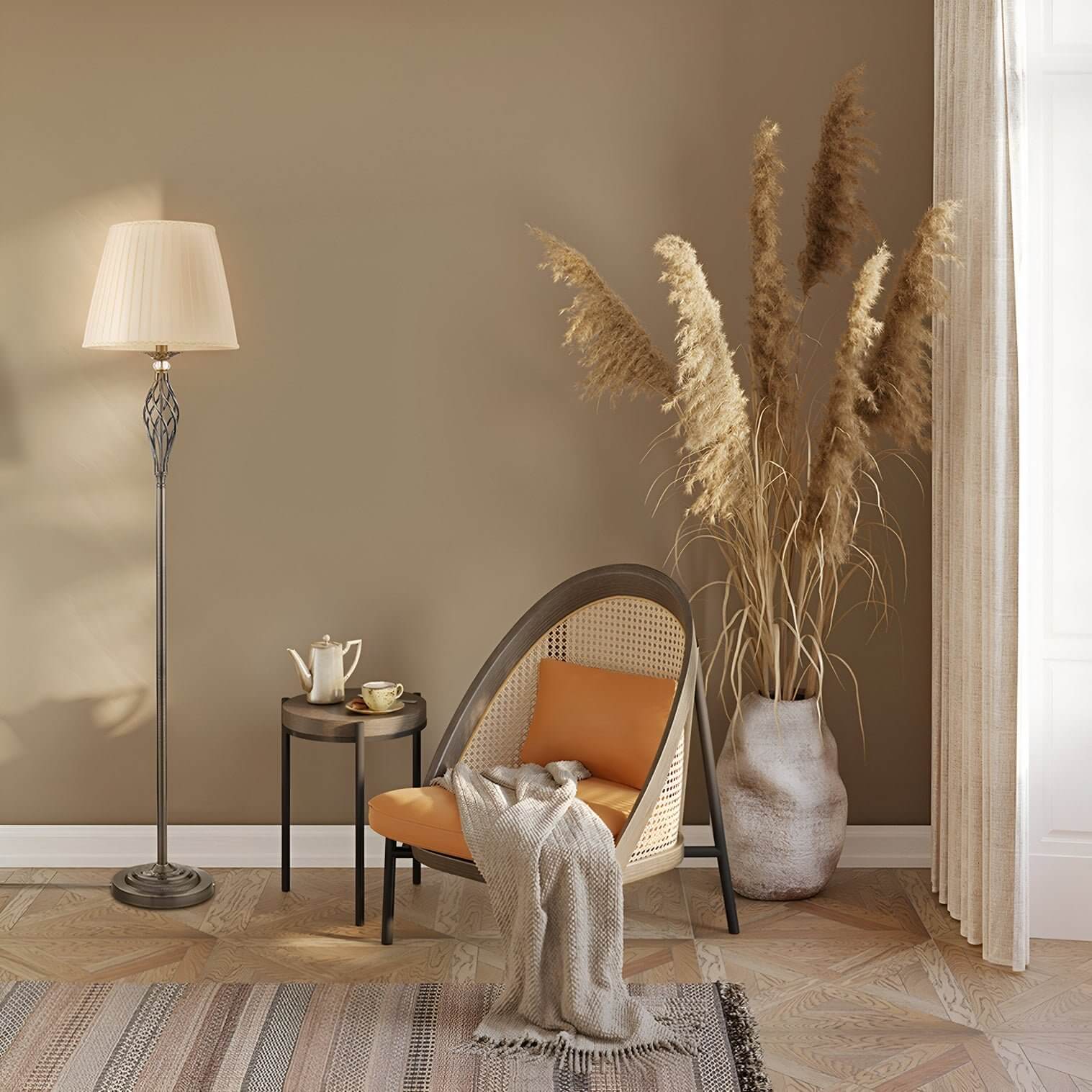 Bronze floor lamp with pleated shade beside a rattan chair in a warm-toned reading nook with pampas grass and textured flooring.