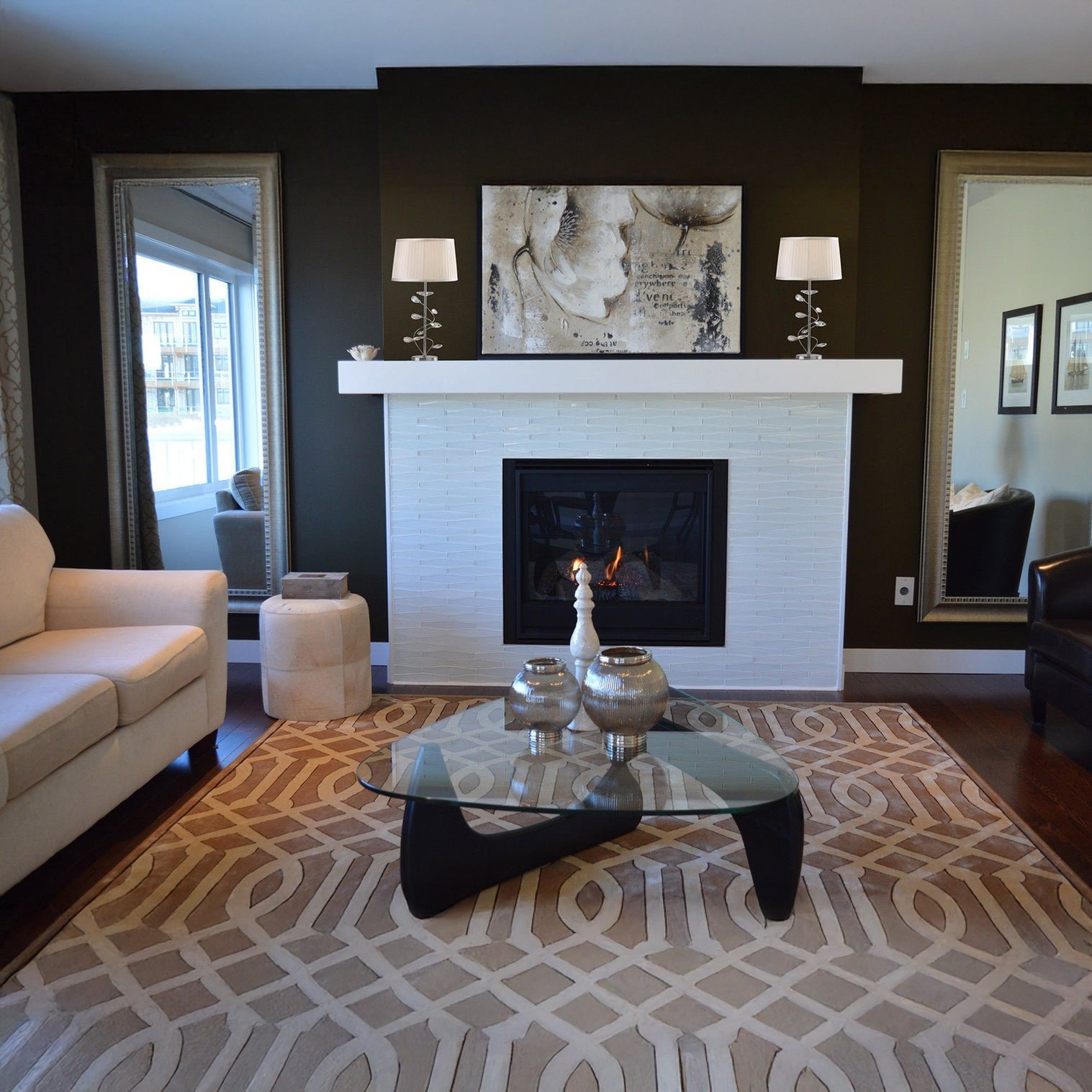 Modern living room with twin silver table lamps on a white mantel framing a fireplace.