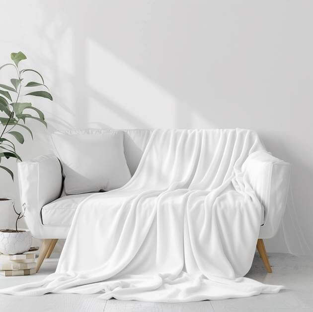 A white couch with a blanketAI-generated content may be incorrect.