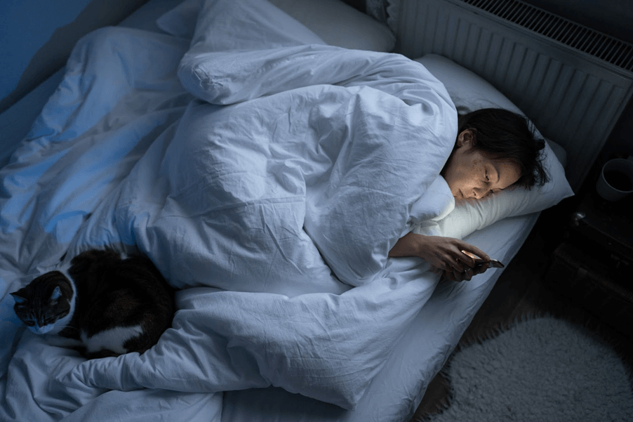 A person lying in bed with a catAI-generated content may be incorrect.