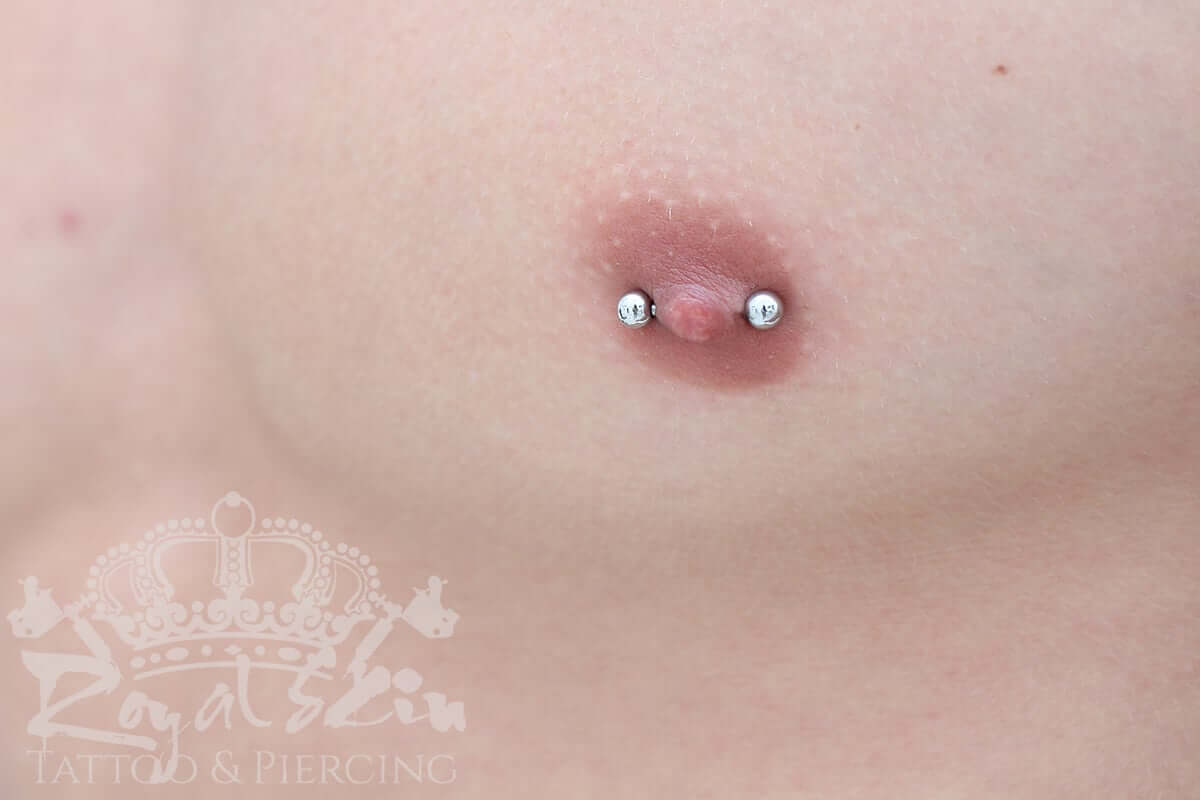 Männliche Brust mit einem Nippelpiercing mit silbernen Titan Barbell Schmuck 