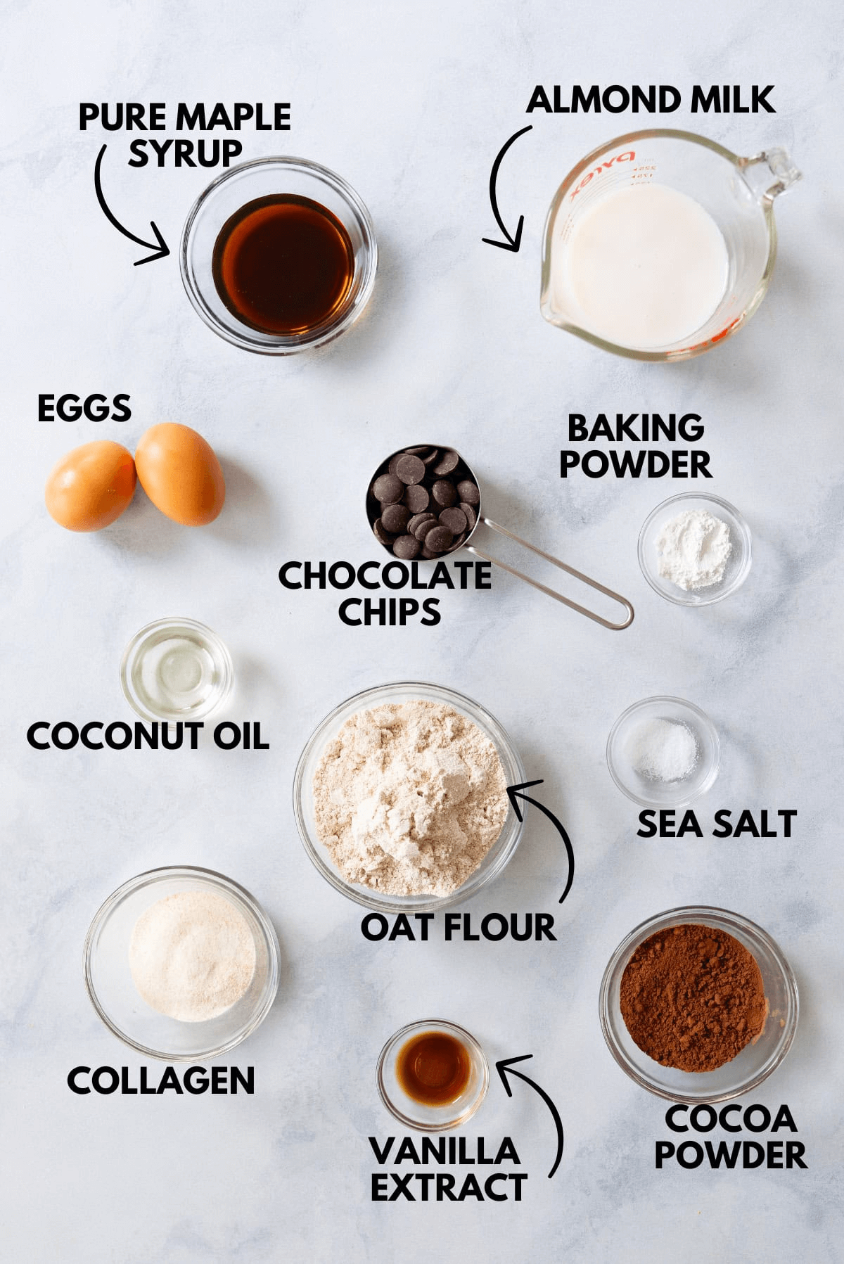 An image with ingredients for Healthy Chocolate Donuts laying flat upon a marbled white surface.