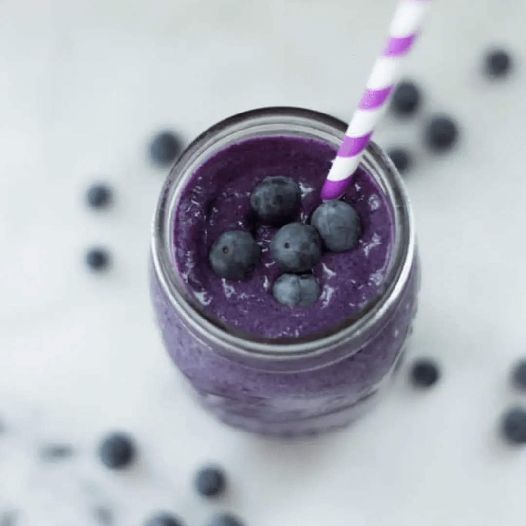 A photo of Fit + Slim Smoothie plated with blueberries in the background