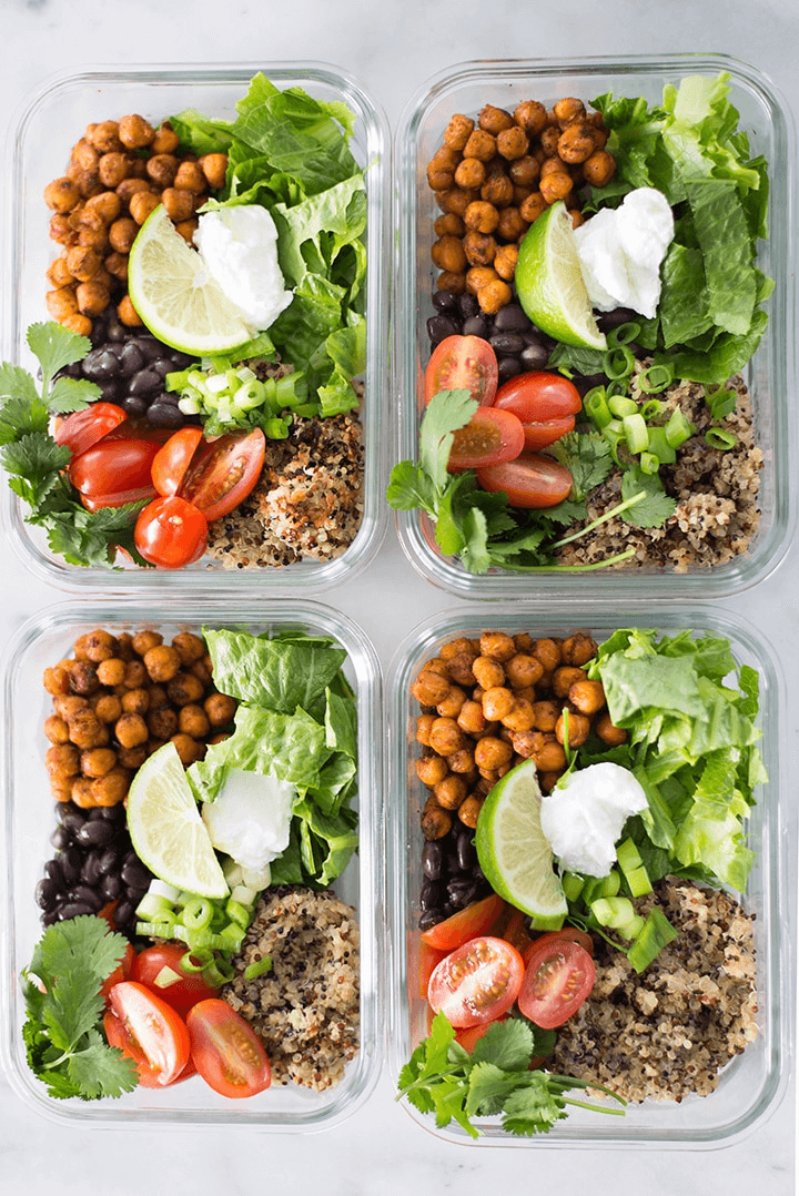 A photo of 4 meal prep containers all full of Chipotle Chickpea Taco Bowl Meal Prep.