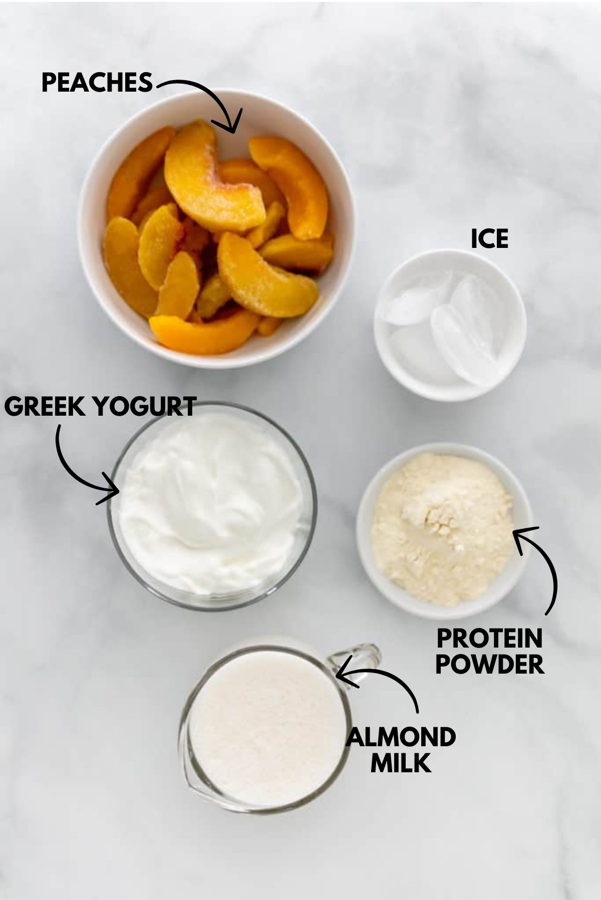 A photo of ingredients for peach protein shake laying flat against a marble white background.