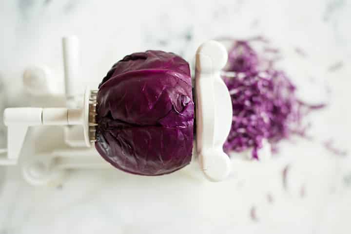 Overhead view of a red cabbage being spiralized to show how to spiralize cabbage.