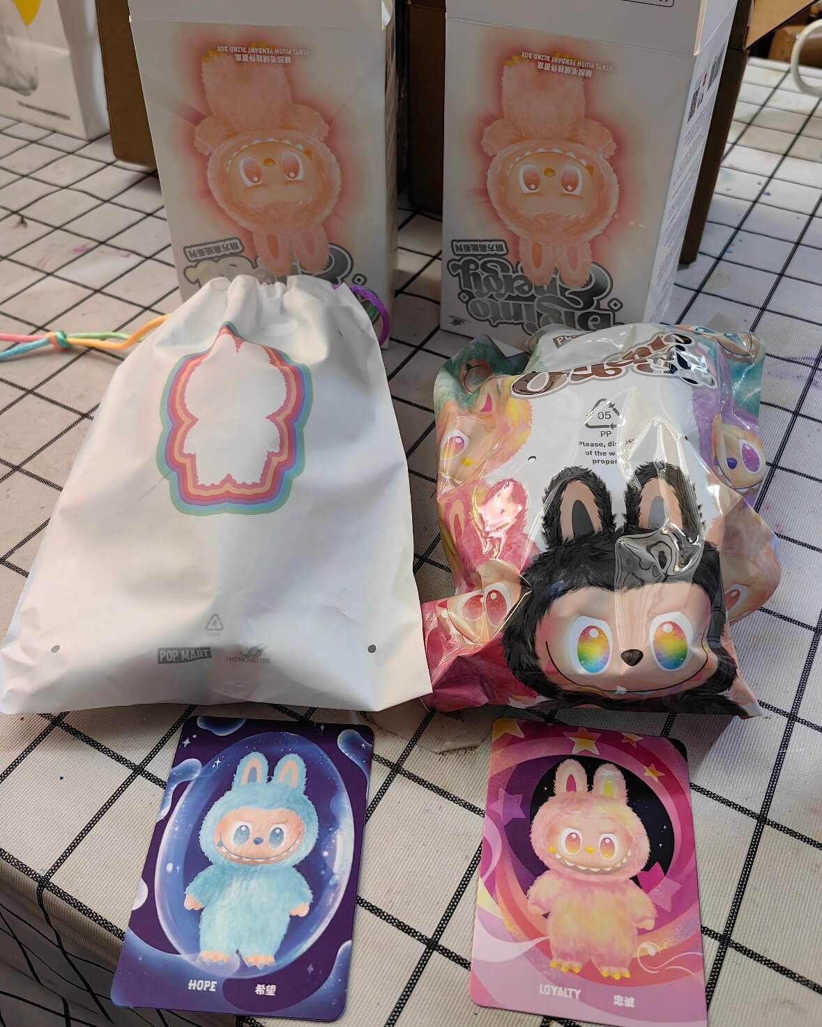 Comparison of old sealed Labubu bag and new reusable drawstring pouch
