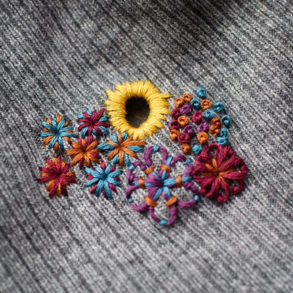 Fixing a holey sweater with embroidery - great visible mending idea from Hunter Hammersen!