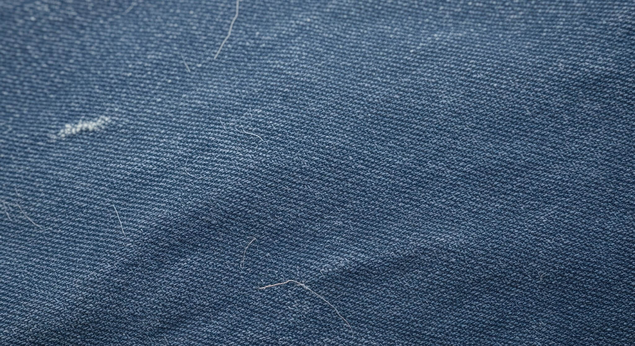 Close-up of worn denim fabric highlighting stitching and texture from the most durable clothing brands known for long-lasting craftsmanship.