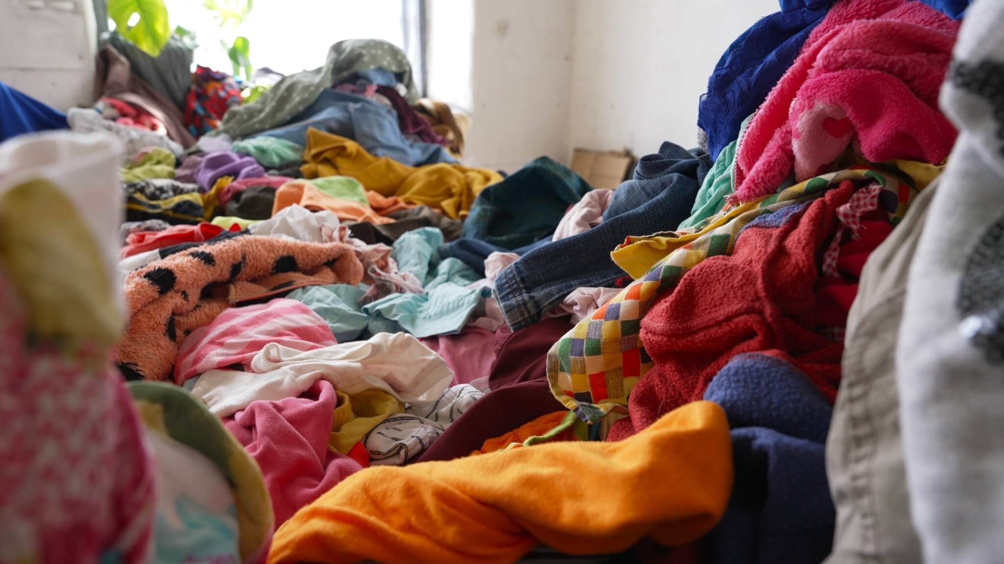 Pile of discarded synthetic fabrics, highlighting the environmental impact of non-biodegradable textiles.