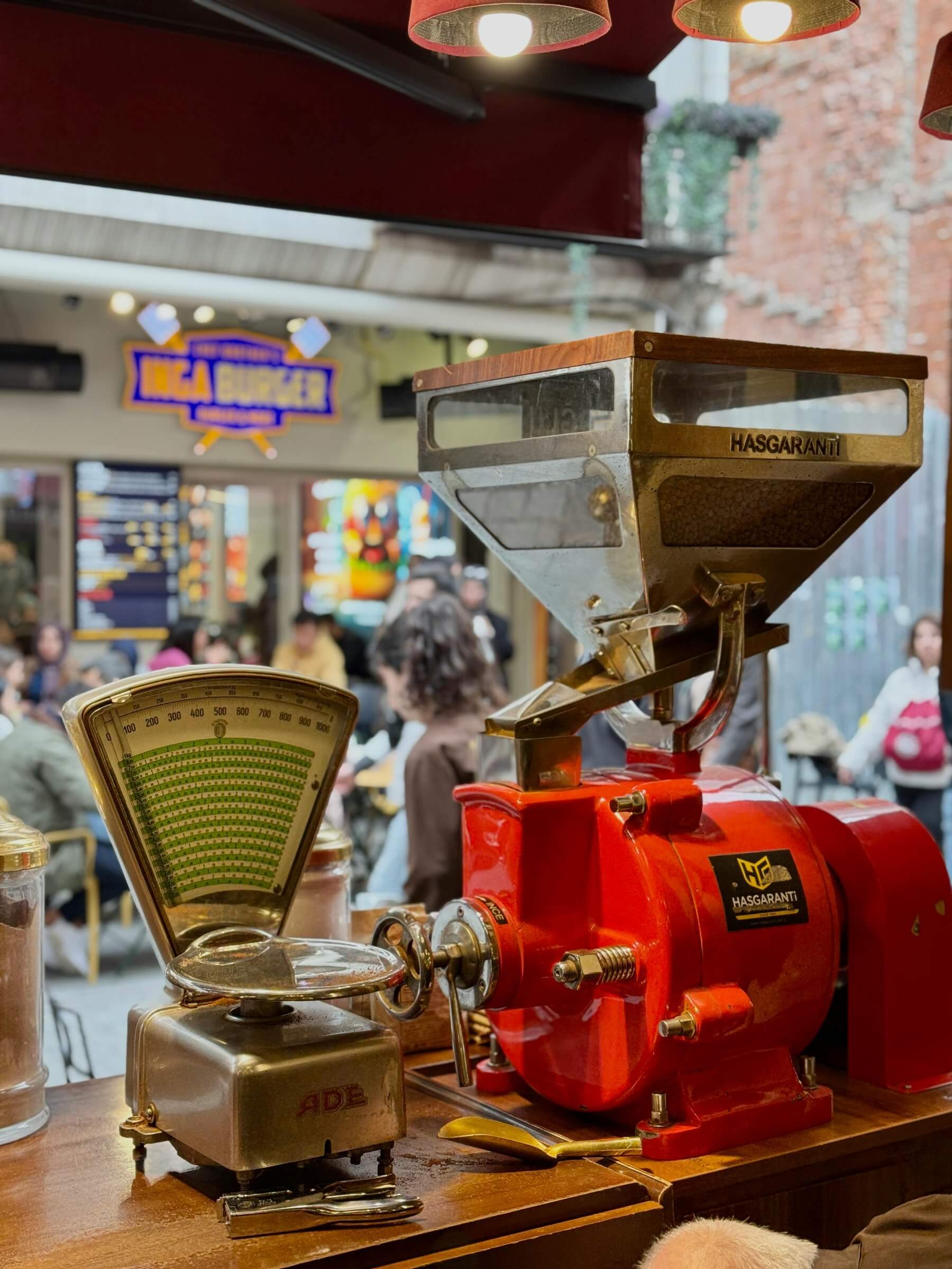 A vibrant scene capturing a vintage coffee grinder in a bustling İstanbul café.