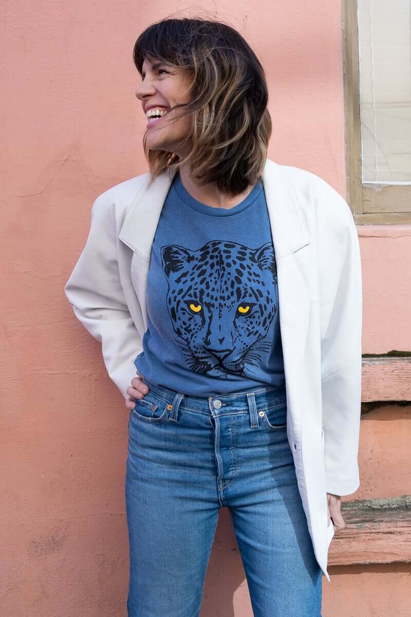 Angela wearing a Thread Hippie women’s graphic tee styled with a white leather blazer and denim jeans.