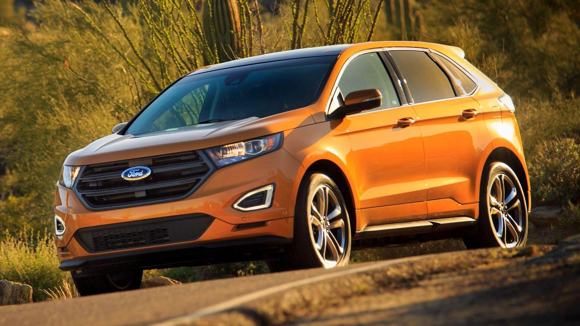Orange Ford Edge driving on the road, offering roomy accommodations.
