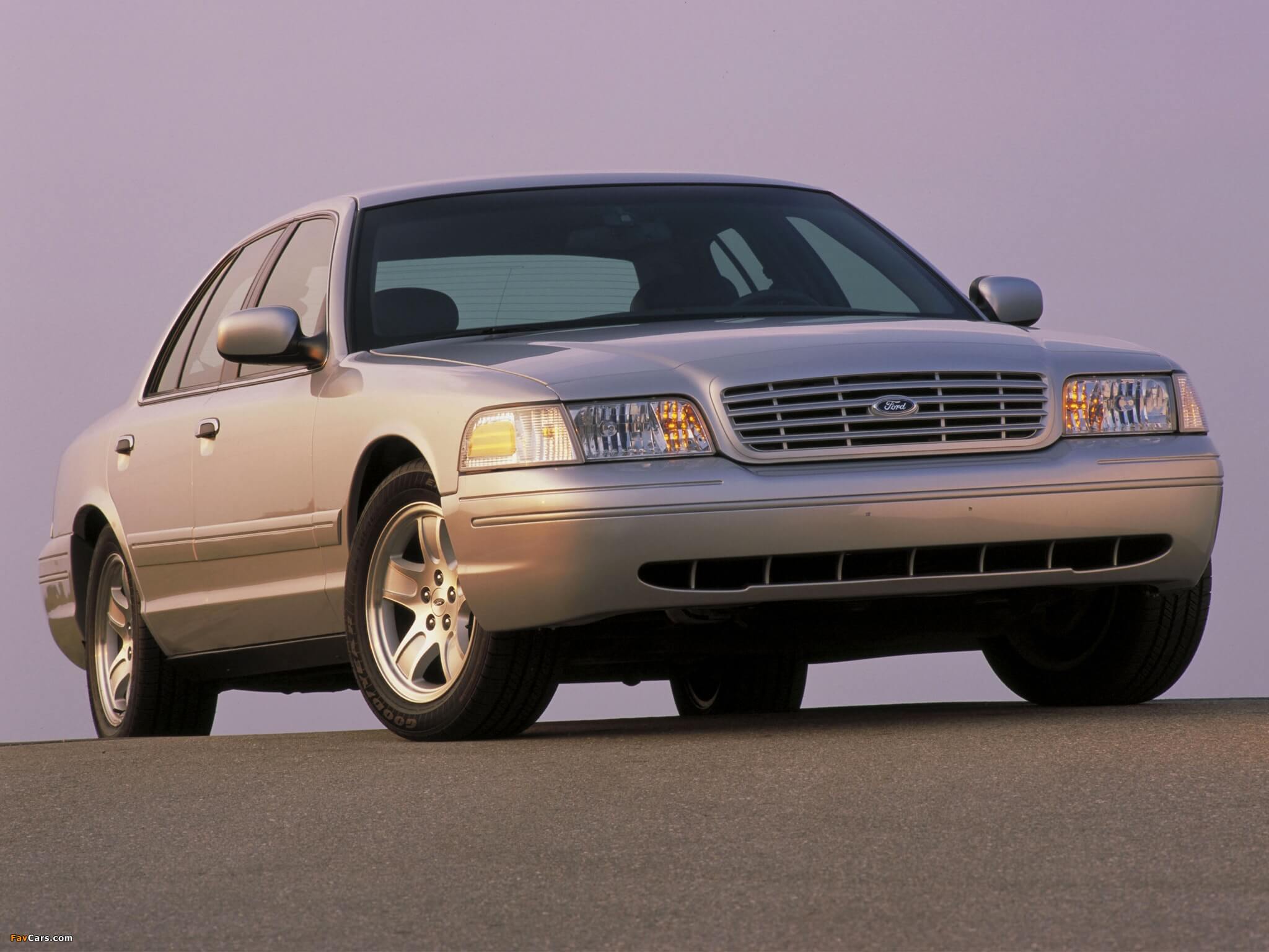 1998 Ford Crown Victoria car, silver in color, parked on pavement.