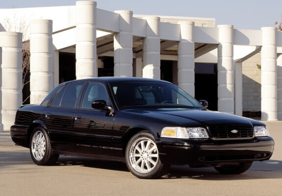 Black Ford Crown Victoria parked in front of a building.