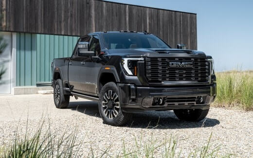Black GMC vehicle in front of a building.