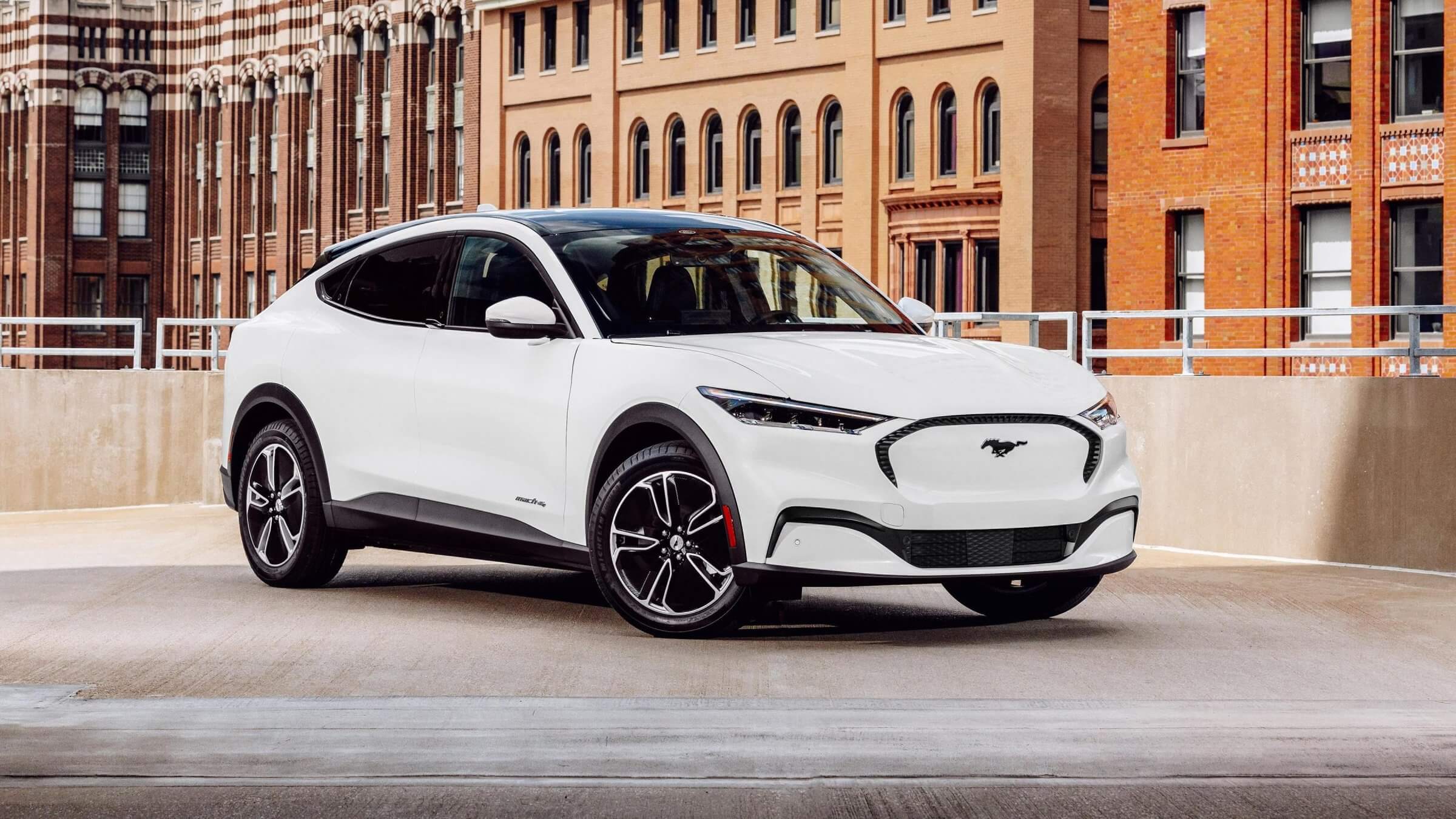 White 2024 Ford Mach-E parked in front of a building.