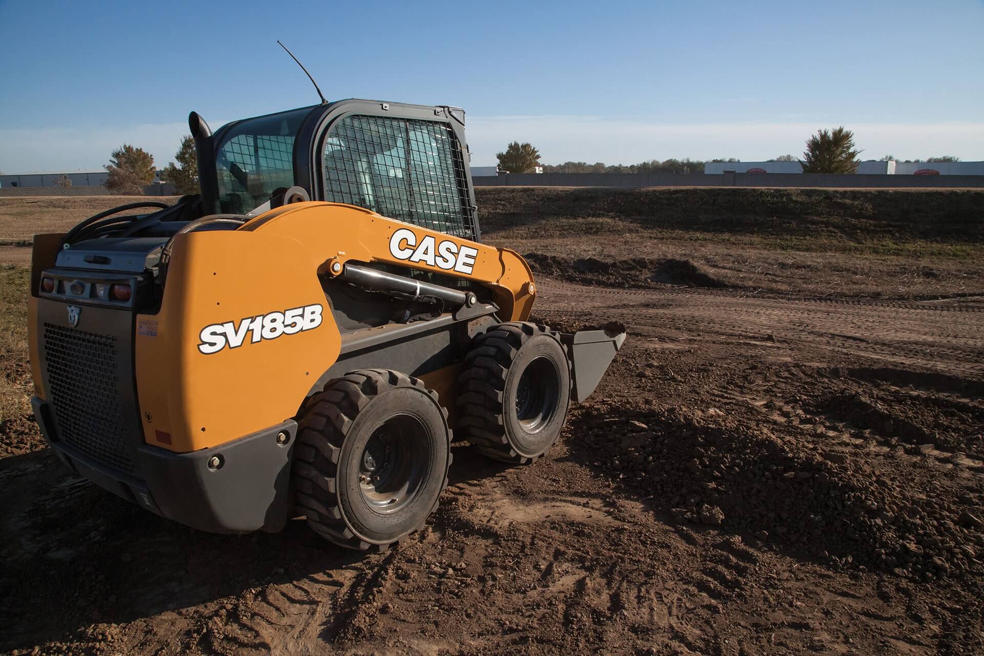 Orange skid steer in a field of dirt.