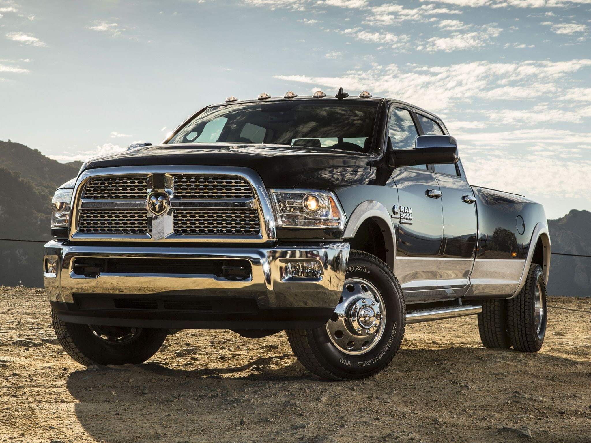 Black Ram truck with crew cab and comfortable front seats parked on a dirt road.