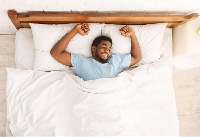 Man Waking Up in White SHEEX Bed Sheets Feeling Happy