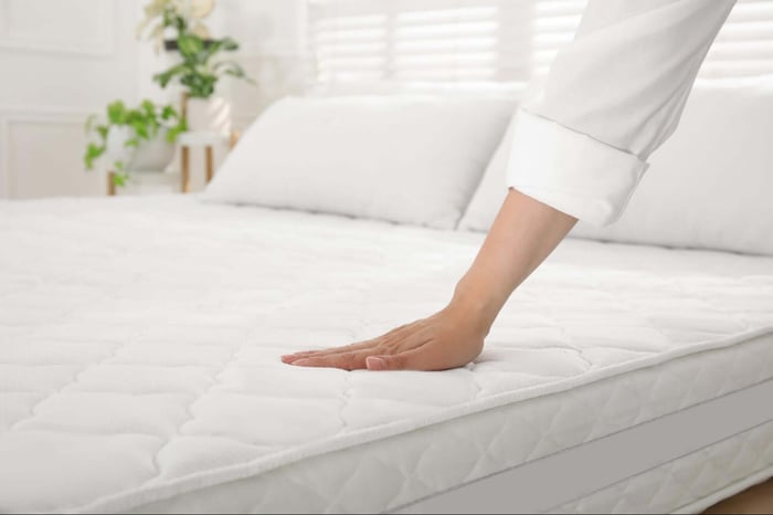 Woman Pressing on a Mattress to Check the Firmness