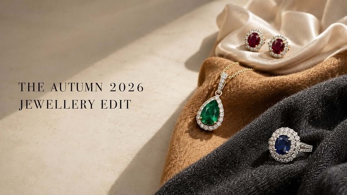 The autumn 2026 jewellery edit, Ruby, emerald and blue sapphire jewellery with natural diamond accents arranged on autumn fabrics.