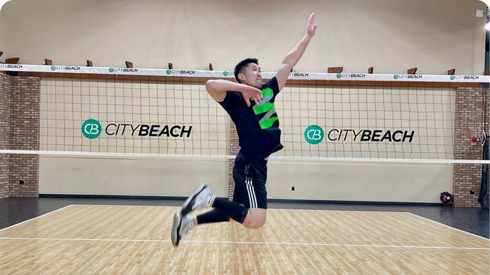 Prevent Jumper's Knee: Volleyball player jumping for a spike during indoor training session.