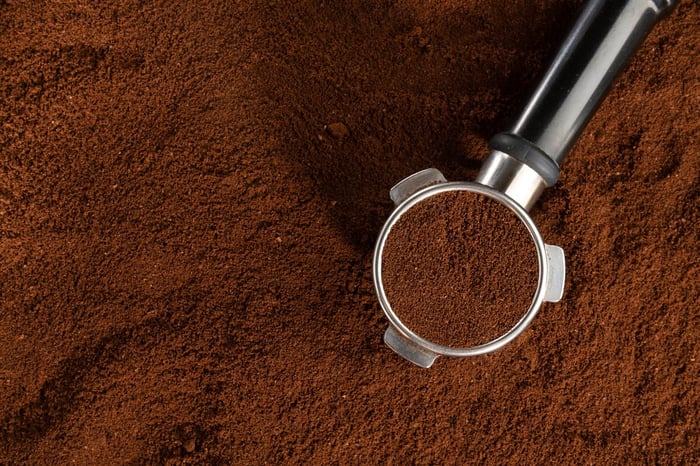 Espresso machine portafilter with finely textured coffee grounds.