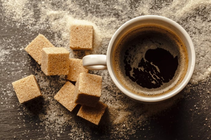 cup of black coffee with brown sugar cubes