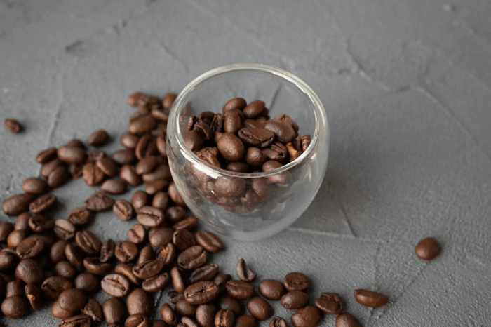 Coffee beans in clear glass cup.