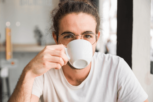 Person drinking cup of coffee.
