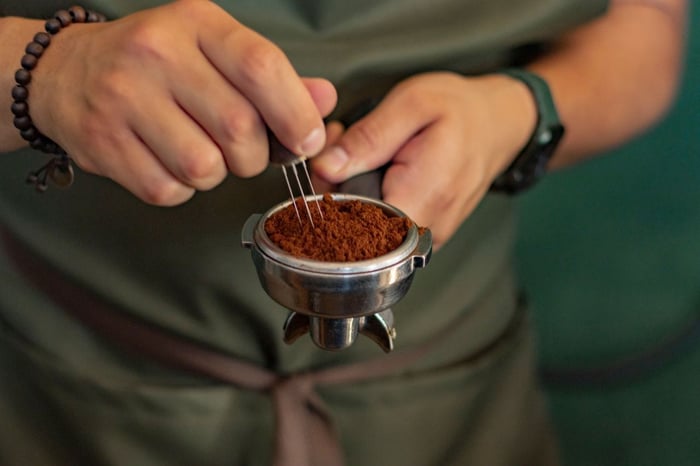 Person preparing ground coffee for brewing