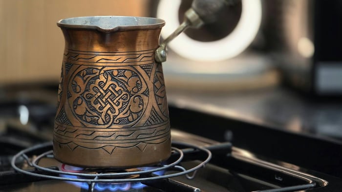 Copper Turkish coffee pot on stove.