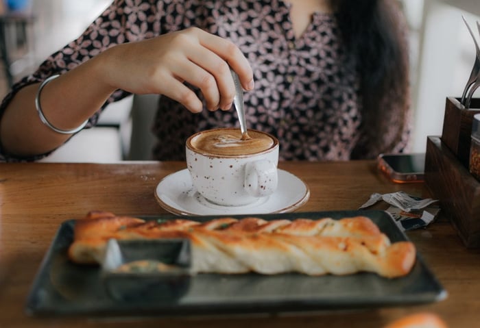 Person stirring a cup of coffee