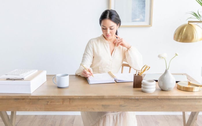 a pensive moment with a day designer planner, at a deskwith written on planner page, open planner at a desk, gold monthly tabs, candle, keyboard