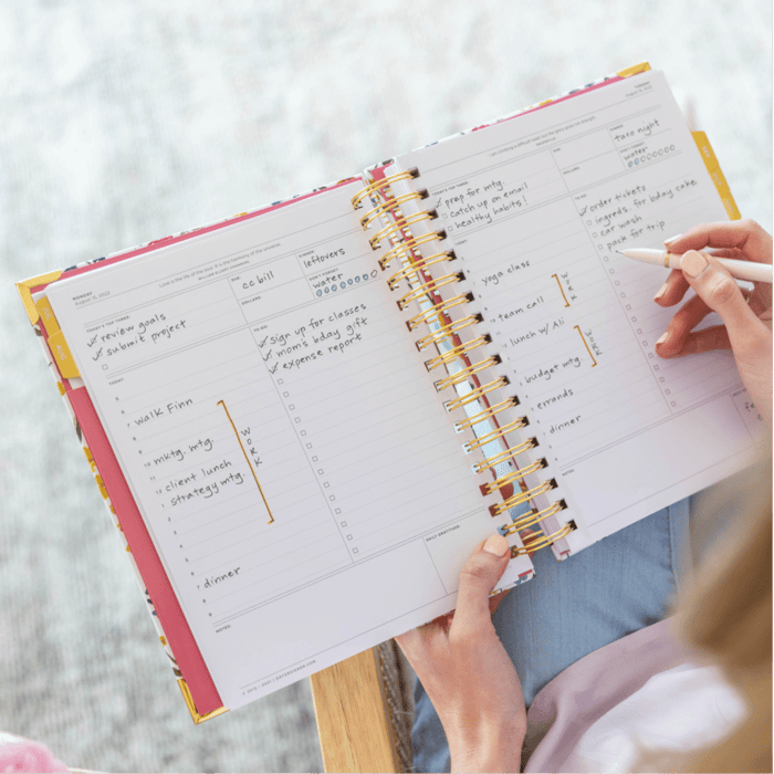 how to plan, woman holding day designer planner, open book with writing on pages