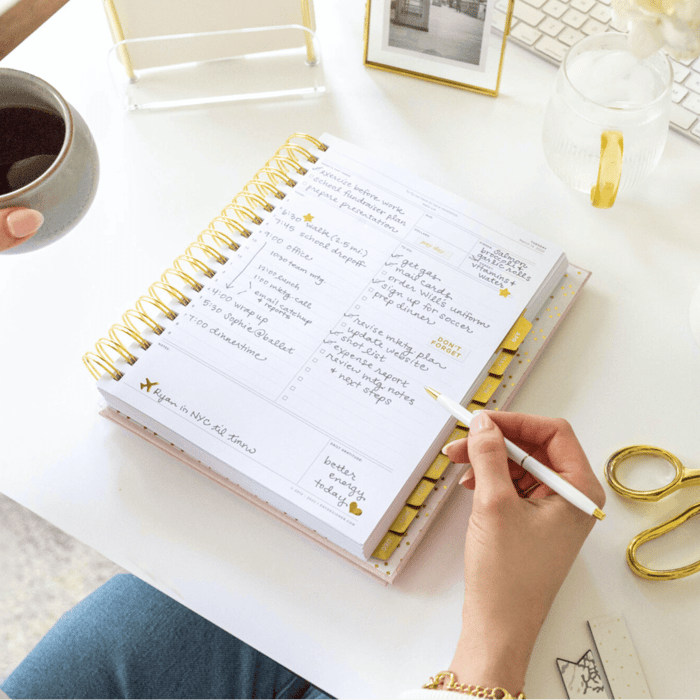 Make your life easier! open day designer planner with written on page, hand holding pen
