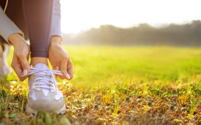 woman tying shoe, grass, trees, wake up motivated