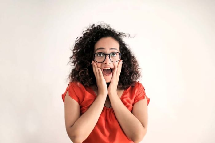 a curly hair woman pretending to be surprised