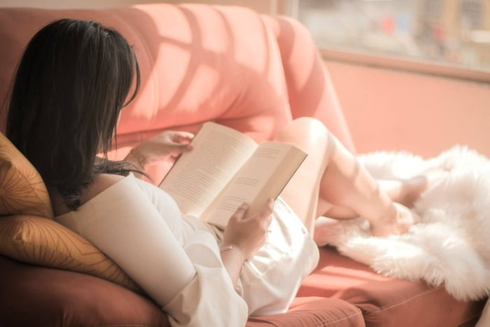 woman reading in cozy sunlit living room.