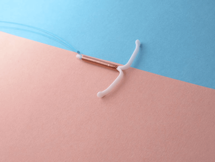 Copper IUD on pastel colored background