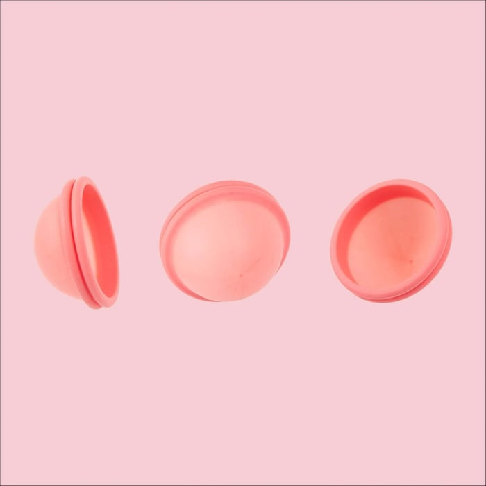 Pink menstrual disc shown from side, top, and interior views.
