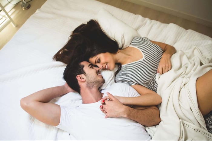 Man and woman cuddling on bed