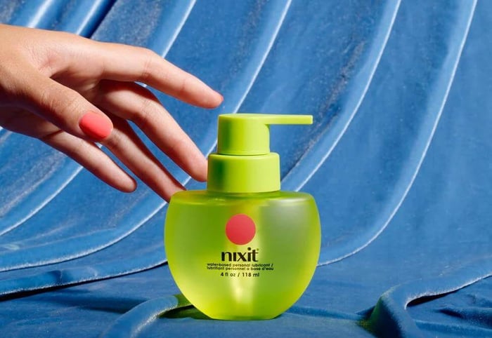 nixit water-based lubricant bottle with hand reaching toward pump
