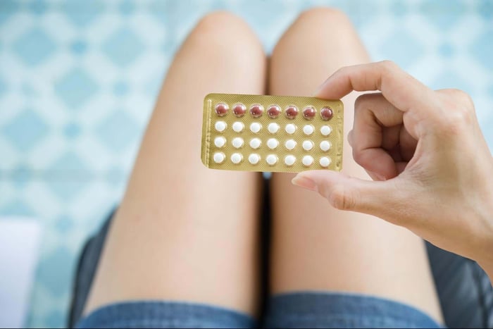 A woman holding a packet of contraceptive pills