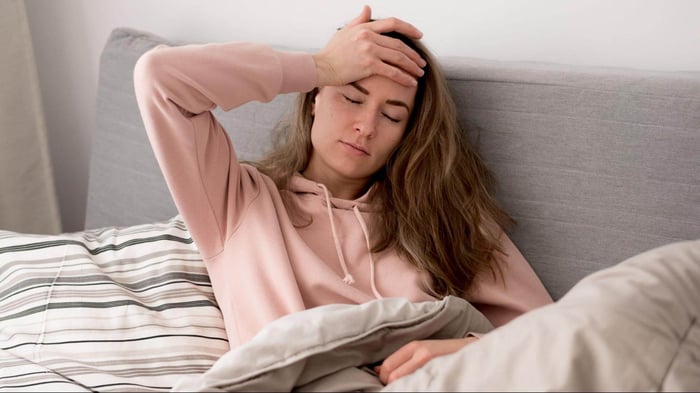 Woman sitting on sofa looking unwell