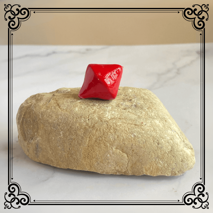 A handmade polymer clay scarlet bicone